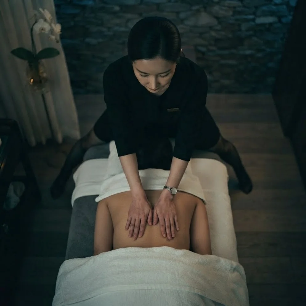 Illustrative hands-on massage in a softly lit private room